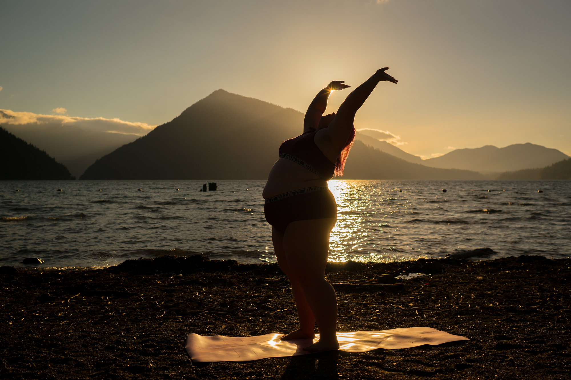 A fat woman in a swimsuit outdoors by a lake in Washington at dusk