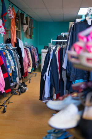 A clothing store with teal walls is clean and ready for business during a small business photo session in Seattle