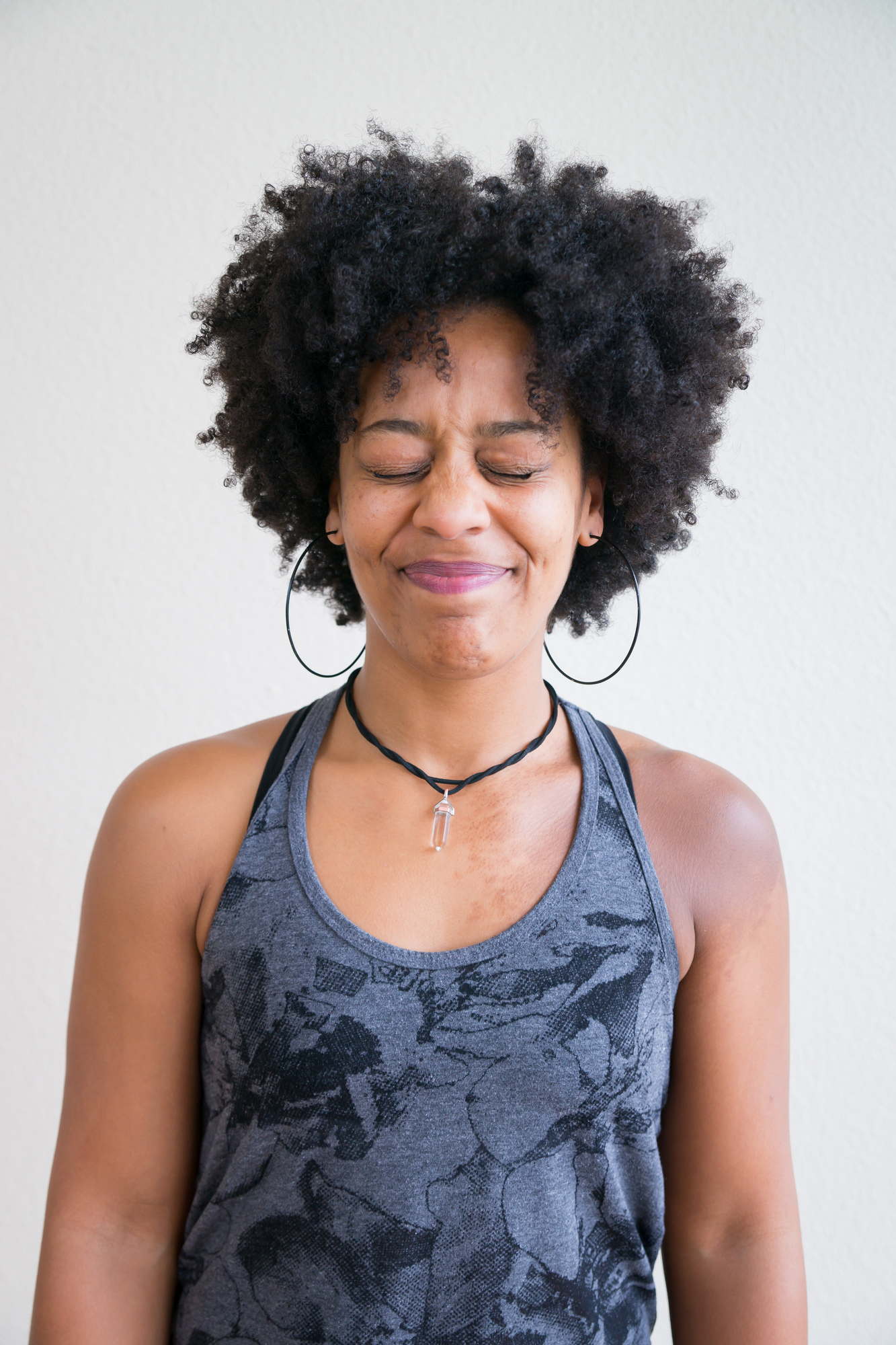 A Black woman closes her eyes with a frustrated expression