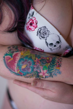 A fat woman cradles her tattooed arm during a photo session in Seattle