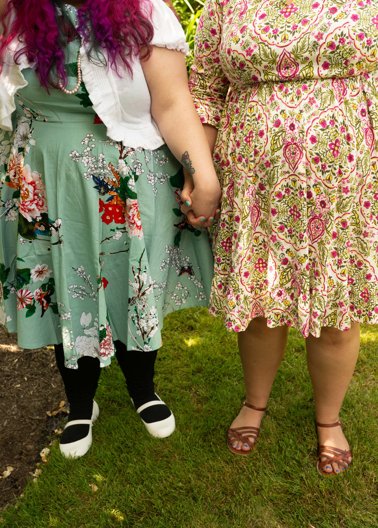 Two fat women wearing dresses hold hands in a lgbt friendly photo shoot