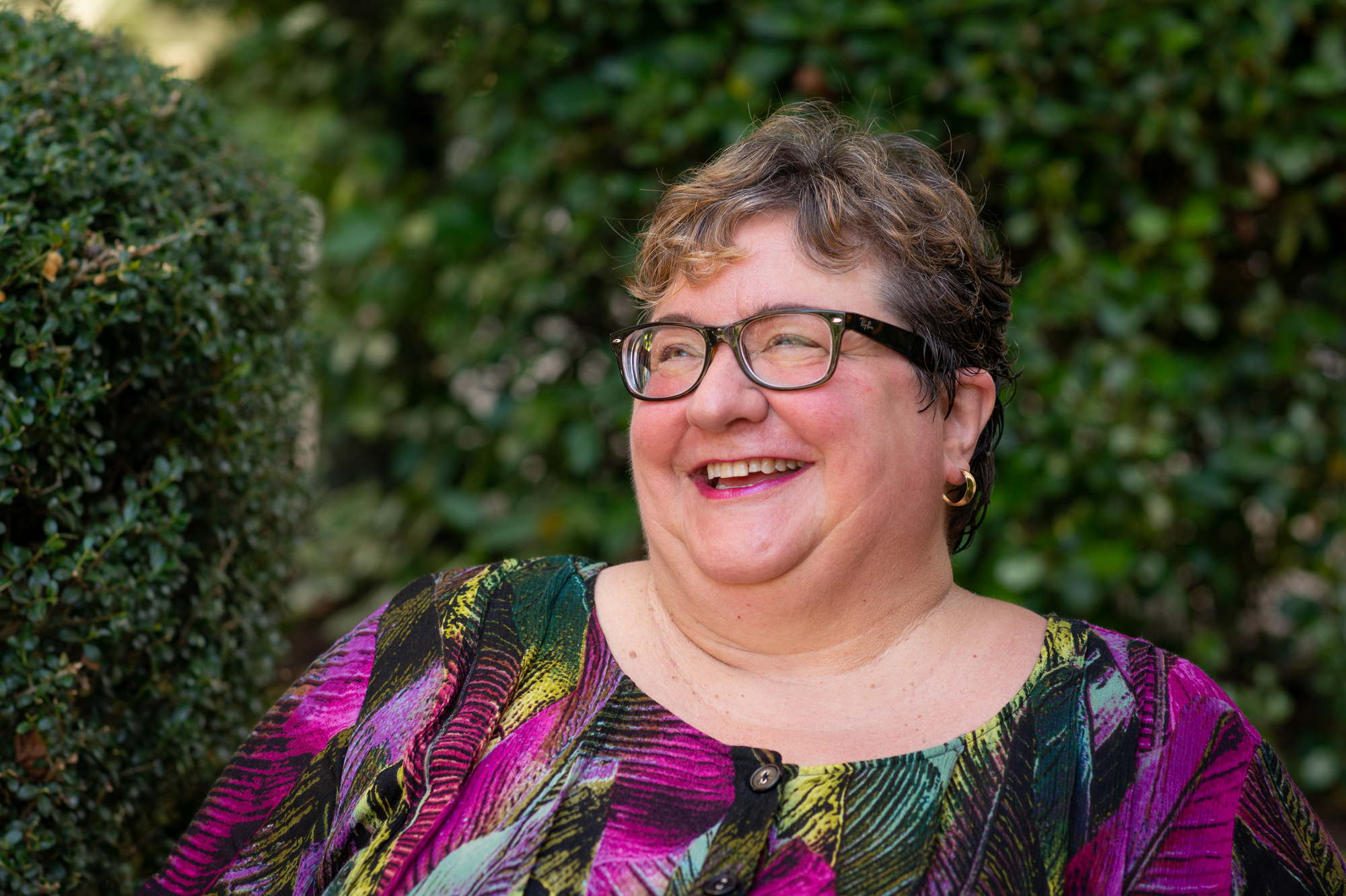 A fat woman laughs looking off to the left for a headshot shoot in the PNW