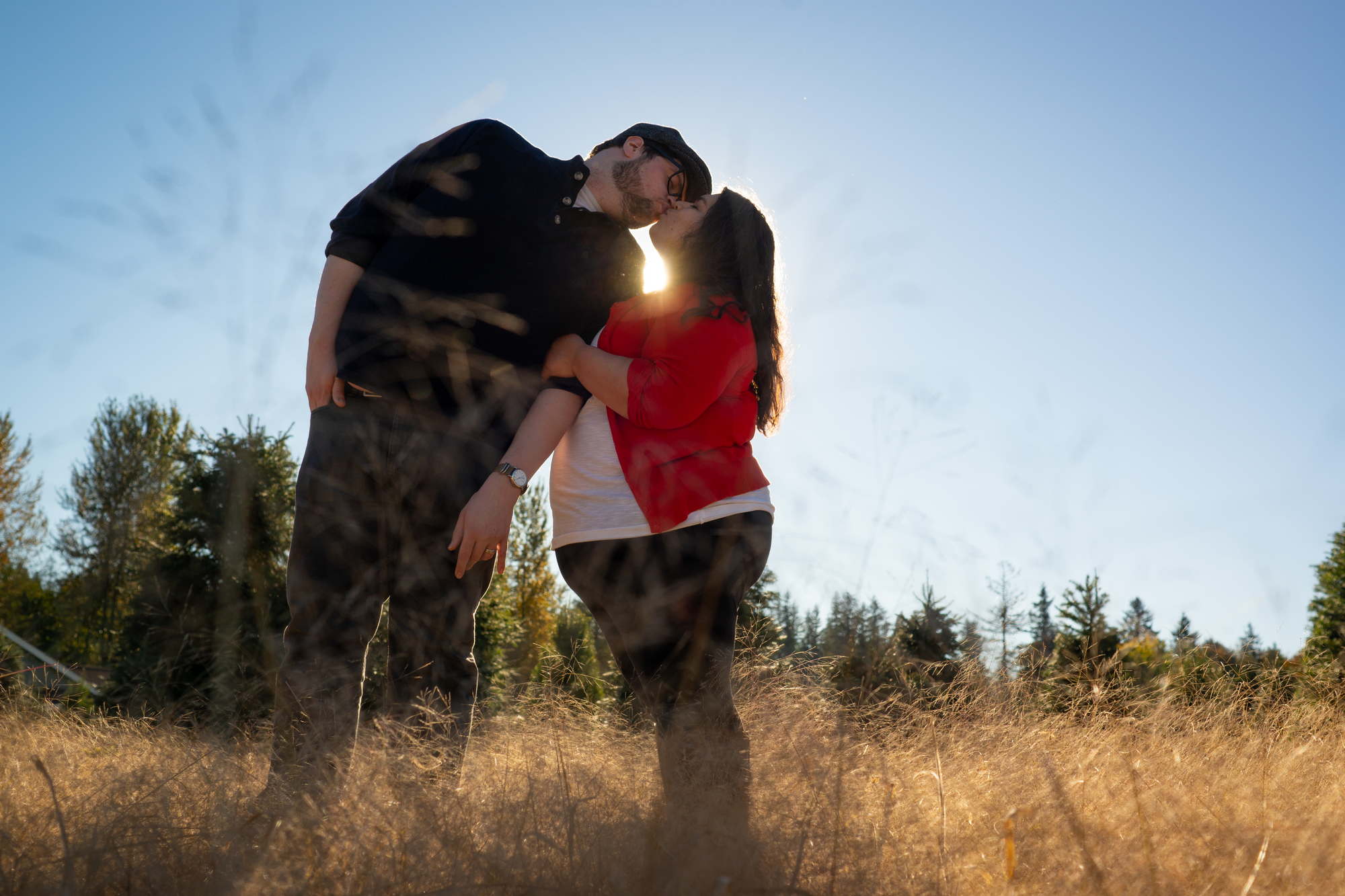 A fat couple kiss in a field in the PNW