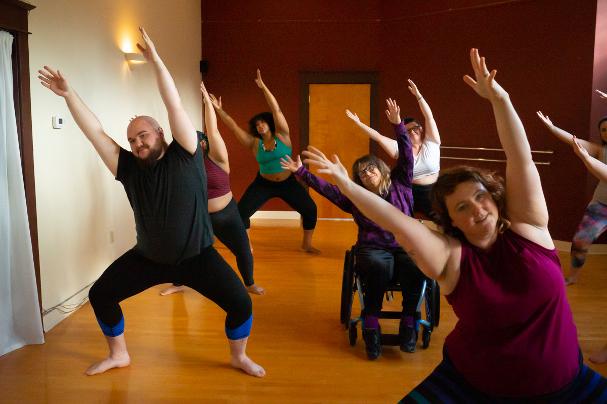 A group of people demonstrate a yoga pose during a small business session in Seattle 