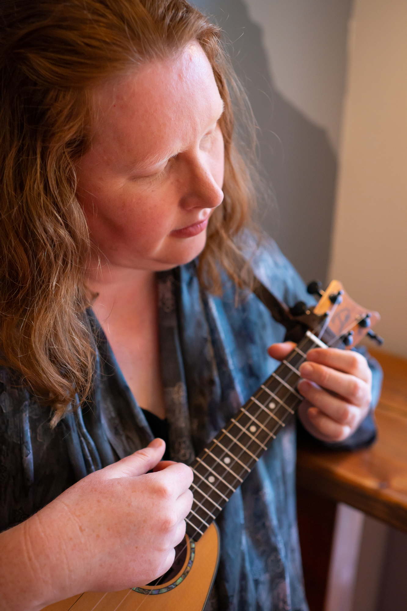 A fat woman playing a ukulele