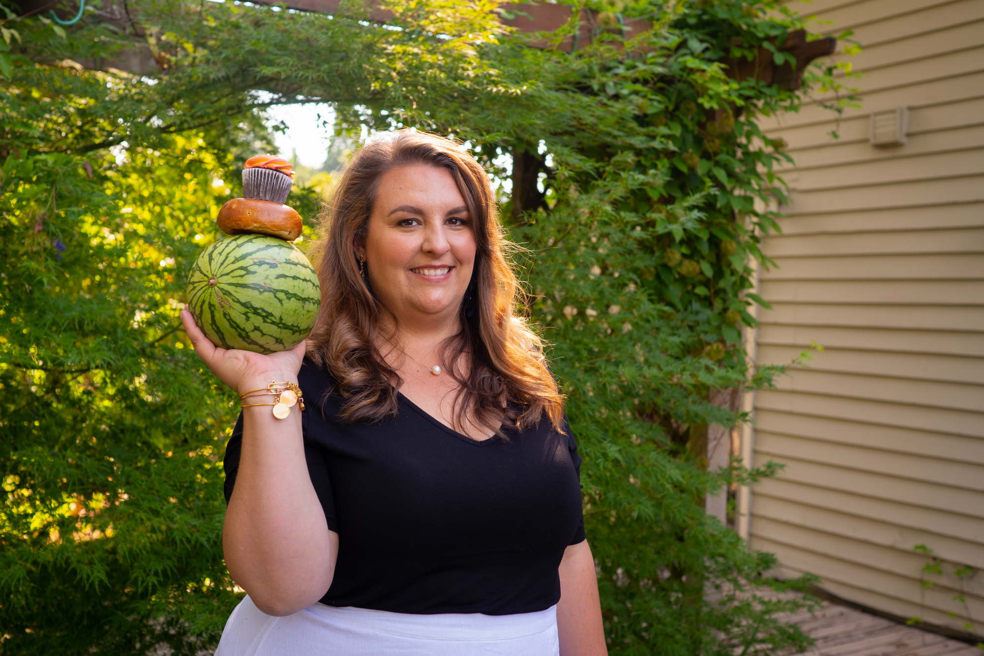 A fat woman poses confidently while holding a watermelon outdoors in the PNW