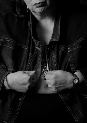 A fat woman opens a denim jacket during a boudoir photo shoot