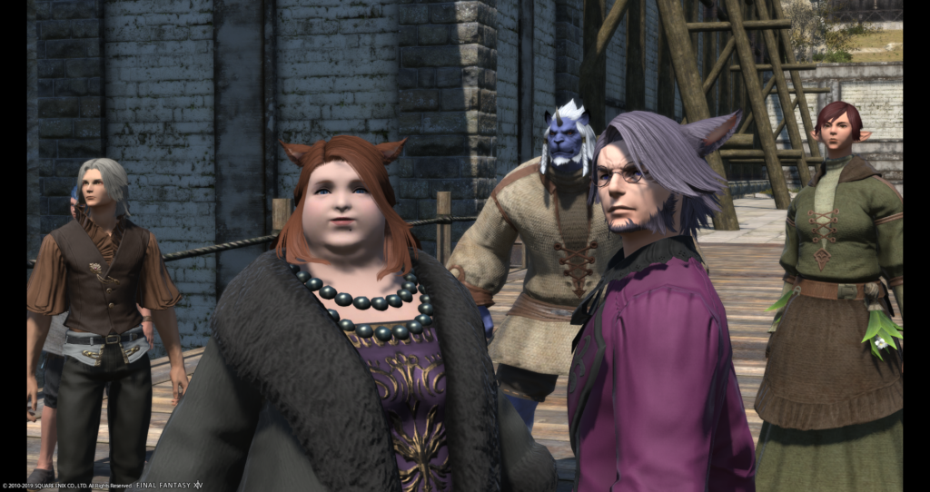 A character from the MMO Final Fantasy XIV, Dulia-Chai, is shown standing in front of a stone wall outdoors. She is fat and pale-skinned, has red hair and cat ears, and is wearing court clothing of a purple and gold full-length dress, black pearls, and black fur coat. A man in a purple coat with purple hair and cat ears stands next to her, with three other fantasy characters in the background.