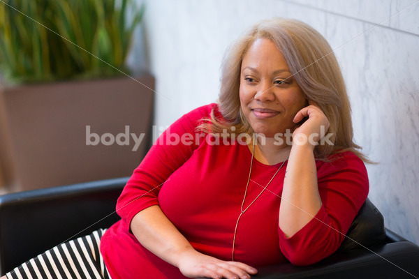 Business Stock Image: Plus Size Black Woman Sitting in Office Building Lobby - Body Liberation Photos