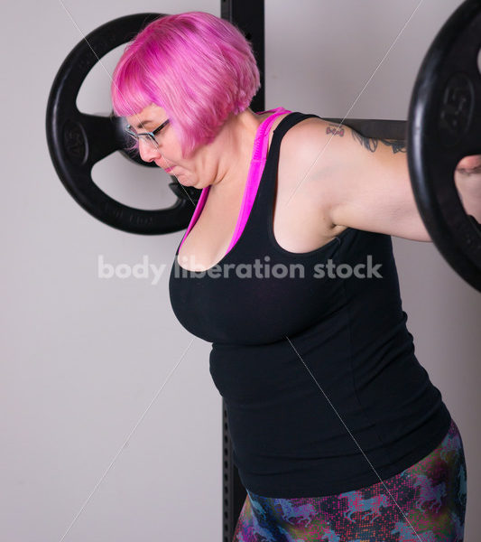 HAES Stock Photo: Female Weightlifter with Pink Hair Does Squat in Gym - Body Liberation Photos