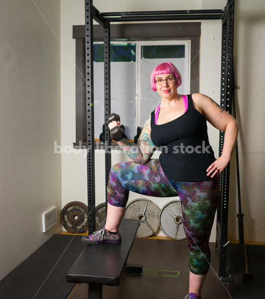 HAES Stock Photo: Female Weightlifter with Pink Hair Lifts Hand Weights in Gym - Body Liberation Photos