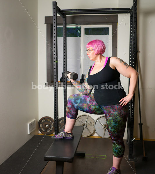 HAES Stock Photo: Female Weightlifter with Pink Hair Lifts Hand Weights in Gym - Body Liberation Photos