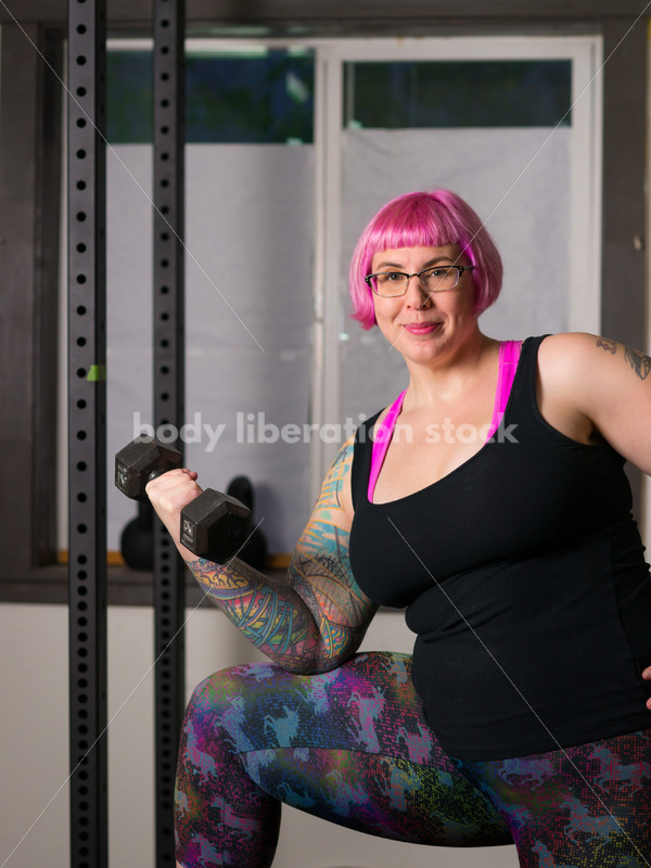 HAES Stock Photo: Female Weightlifter with Pink Hair Lifts Hand Weights in Gym - Body Liberation Photos