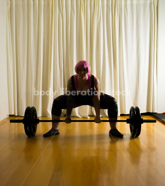 HAES Stock Photo: Female Weightlifter with Pink Hair Lifts Heavy Weight in Gym - Body Liberation Photos