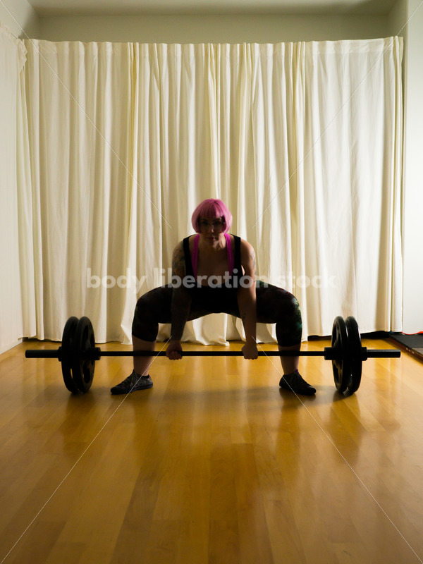 HAES Stock Photo: Female Weightlifter with Pink Hair Lifts Heavy Weight in Gym - Body Liberation Photos
