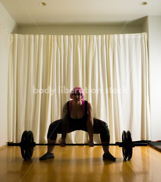 HAES Stock Photo: Female Weightlifter with Pink Hair Lifts Heavy Weight in Gym - Body Liberation Photos