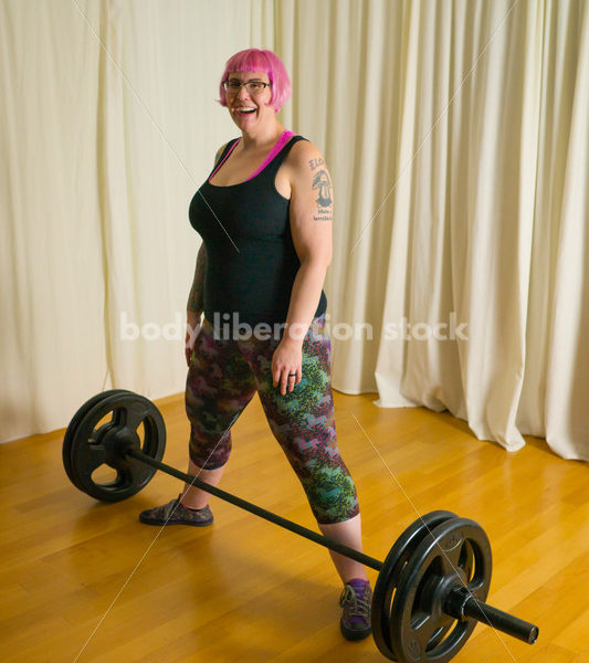 HAES Stock Photo: Female Weightlifter with Pink Hair Lifts Heavy Weight in Gym - Body Liberation Photos