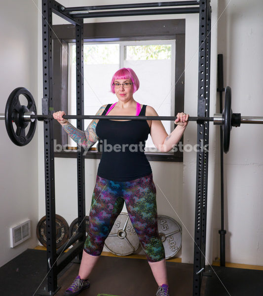 HAES Stock Photo: Female Weightlifter with Pink Hair Standing in Weight Lifting Gym - Body Liberation Photos