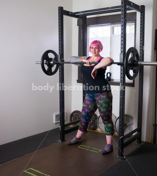 HAES Stock Photo: Female Weightlifter with Pink Hair Standing in Weight Lifting Gym - Body Liberation Photos