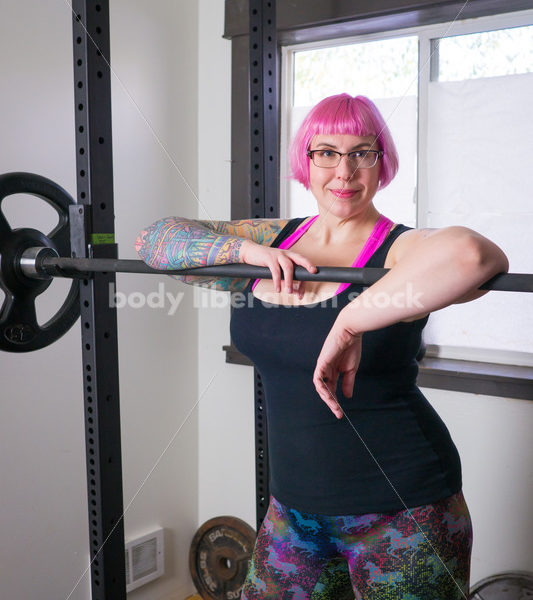 HAES Stock Photo: Female Weightlifter with Pink Hair Standing in Weight Lifting Gym - Body Liberation Photos