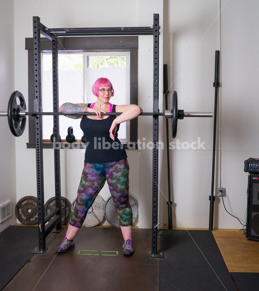 HAES Stock Photo: Female Weightlifter with Pink Hair Standing in Weight Lifting Gym - Body Liberation Photos