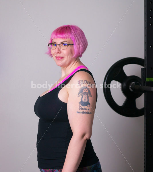 HAES Stock Photo: Female Weightlifter with Pink Hair Standing in Weight Lifting Gym - Body Liberation Photos