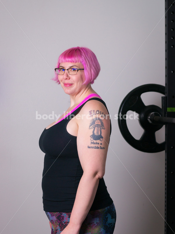HAES Stock Photo: Female Weightlifter with Pink Hair Standing in Weight Lifting Gym - Body Liberation Photos
