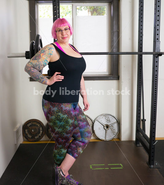 HAES Stock Photo: Female Weightlifter with Pink Hair Stands in Weight Lifting Gym - Body Liberation Photos