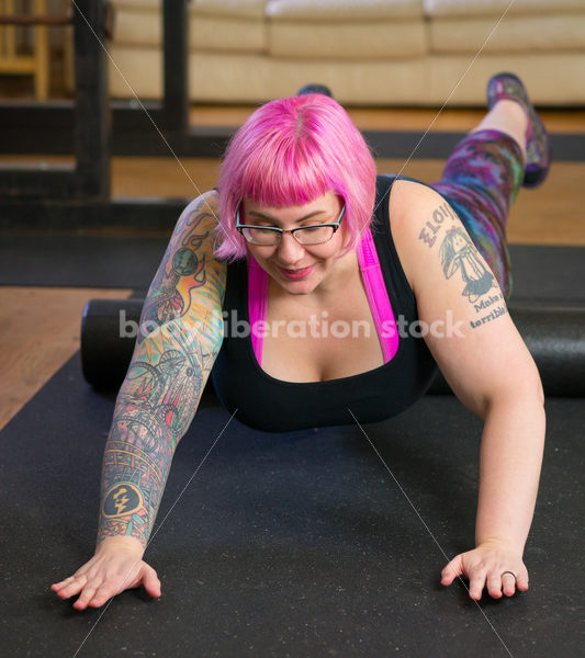 HAES Stock Photo: Female Weightlifter with Pink Hair Warms Up with Foam Roller in Gym - Body Liberation Photos