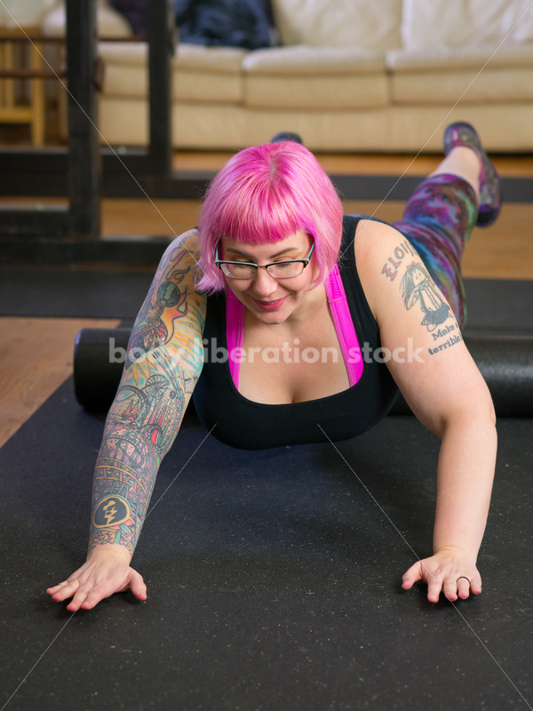 HAES Stock Photo: Female Weightlifter with Pink Hair Warms Up with Foam Roller in Gym - Body Liberation Photos