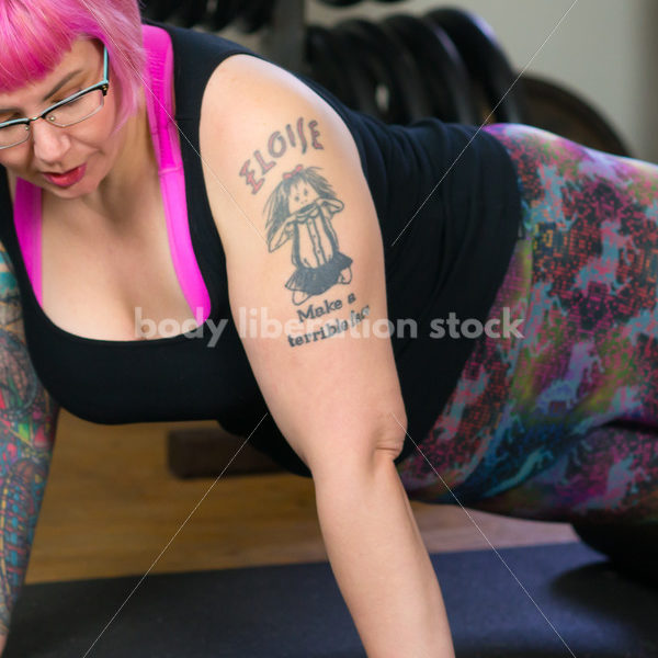 HAES Stock Photo: Female Weightlifter with Pink Hair Warms Up with Foam Roller in Gym - Body Liberation Photos