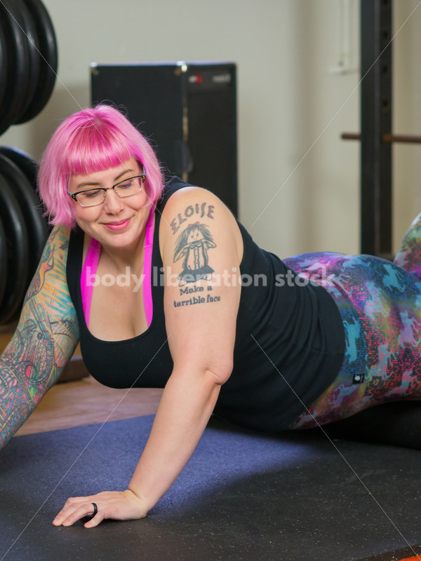 HAES Stock Photo: Female Weightlifter with Pink Hair Warms Up with Foam Roller in Gym - Body Liberation Photos