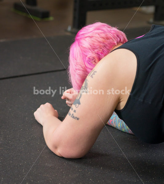 HAES Stock Photo: Female Weightlifter with Pink Hair Warms Up with Foam Roller in Gym - Body Liberation Photos