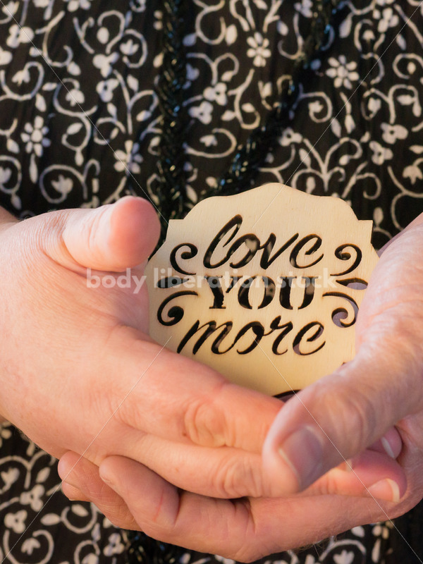 Romance Microstock Image: Older Couple Holding Hands with Love You More Sign - Body Liberation Photos