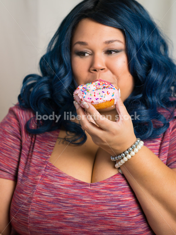 Royalty Free Stock Photo: African American Woman Eats a Doughnut, World Continues to Turn - Body Liberation Photos