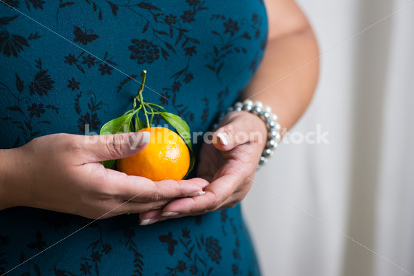 Royalty Free Stock Photo: Black Woman with Satsuma Orange - Body Liberation Photos