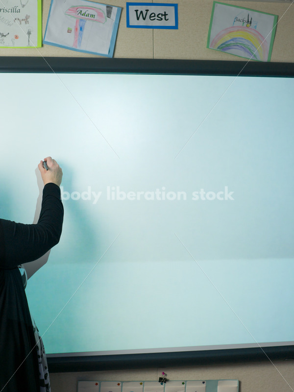 Royalty Free Stock Photo: Plus Size Teacher Writing on Smartboard - Body Liberation Photos