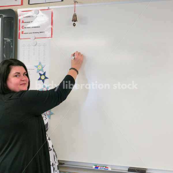 Royalty Free Stock Photo: Plus Size Teacher Writing on Whiteboard - Body Liberation Photos