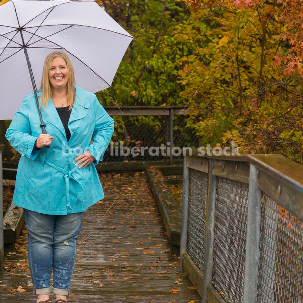 Royalty Free Stock Photo: Plus Size Woman Outdoors with Umbrella, Rain and Autumn Leaves - Body Liberation Photos