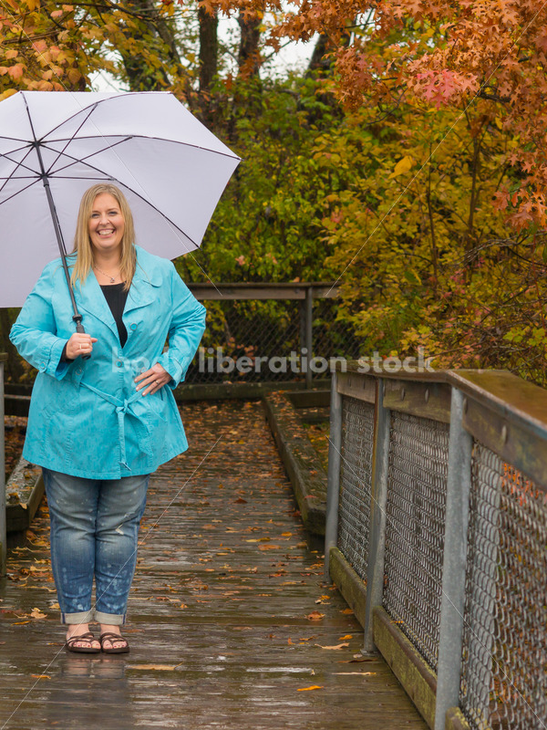 Royalty Free Stock Photo: Plus Size Woman Outdoors with Umbrella, Rain and Autumn Leaves - Body Liberation Photos