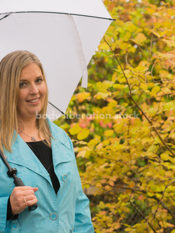 Royalty Free Stock Photo: Plus Size Woman Outdoors with Umbrella, Rain and Autumn Leaves - Body Liberation Photos