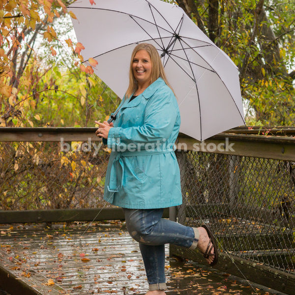 Royalty Free Stock Photo: Plus Size Woman Outdoors with Umbrella, Rain and Autumn Leaves - Body Liberation Photos