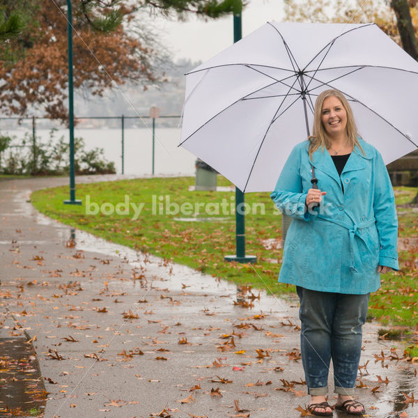 Royalty Free Stock Photo: Plus Size Woman Outdoors with Umbrella, Rain and Autumn Leaves - Body Liberation Photos