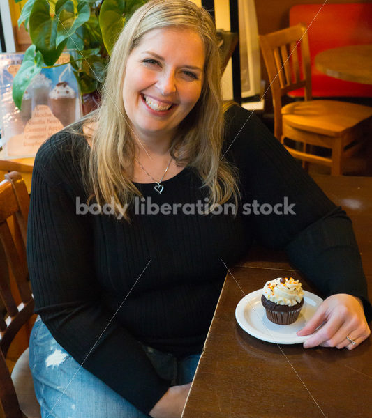 Royalty Free Stock Photo: Plus Size Woman with Cupcake in Coffee Shop - Body Liberation Photos