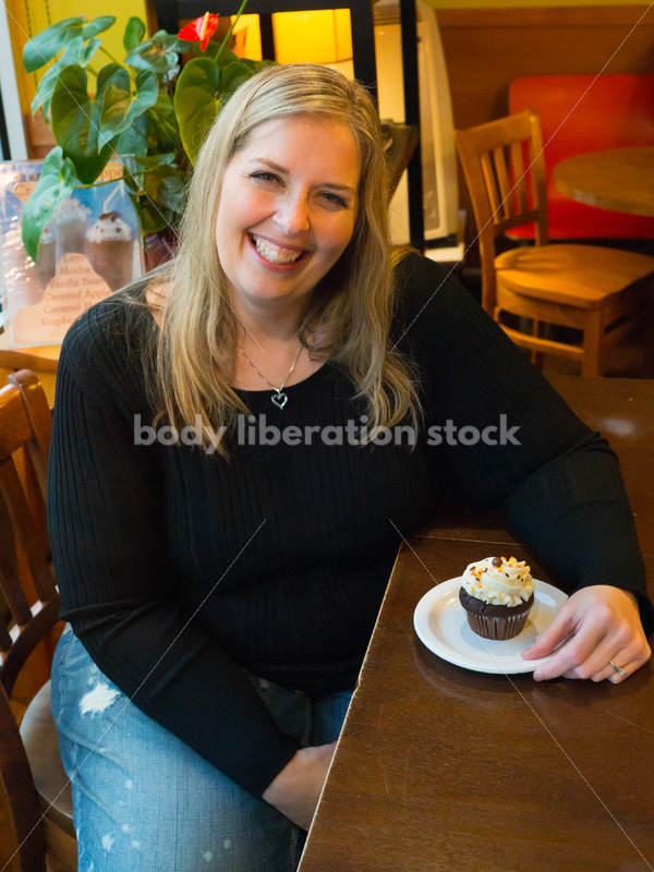 Royalty Free Stock Photo: Plus Size Woman with Cupcake in Coffee Shop - Body Liberation Photos