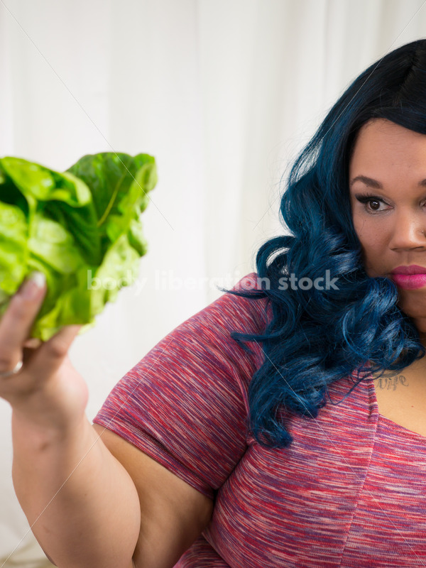 Royalty Free Stock Photo for Intuitive Eating: Black Woman Looks at Head of Lettuce - Body Liberation Photos