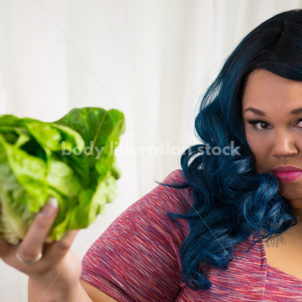 Royalty Free Stock Photo for Intuitive Eating: Black Woman Looks at Head of Lettuce - Body Liberation Photos