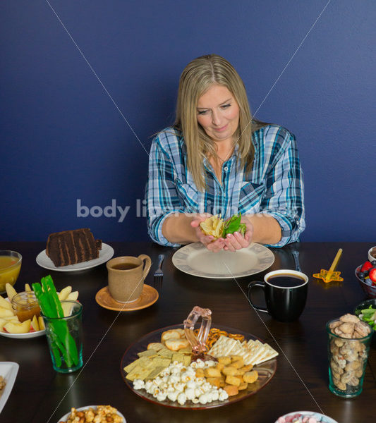 Royalty Free Stock Photo for Intuitive Eating: Plus Size Woman Chooses from Variety of Foods on Dining Table - Body Liberation Photos