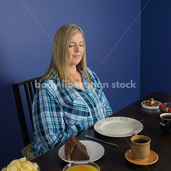 Royalty Free Stock Photo for Intuitive Eating: Plus Size Woman Considers Variety of Foods on Dining Table - Body Liberation Photos