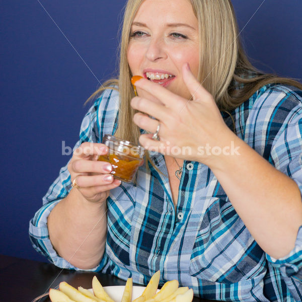 Royalty Free Stock Photo for Intuitive Eating: Plus Size Woman Eats Caramel Dip - Body Liberation Photos